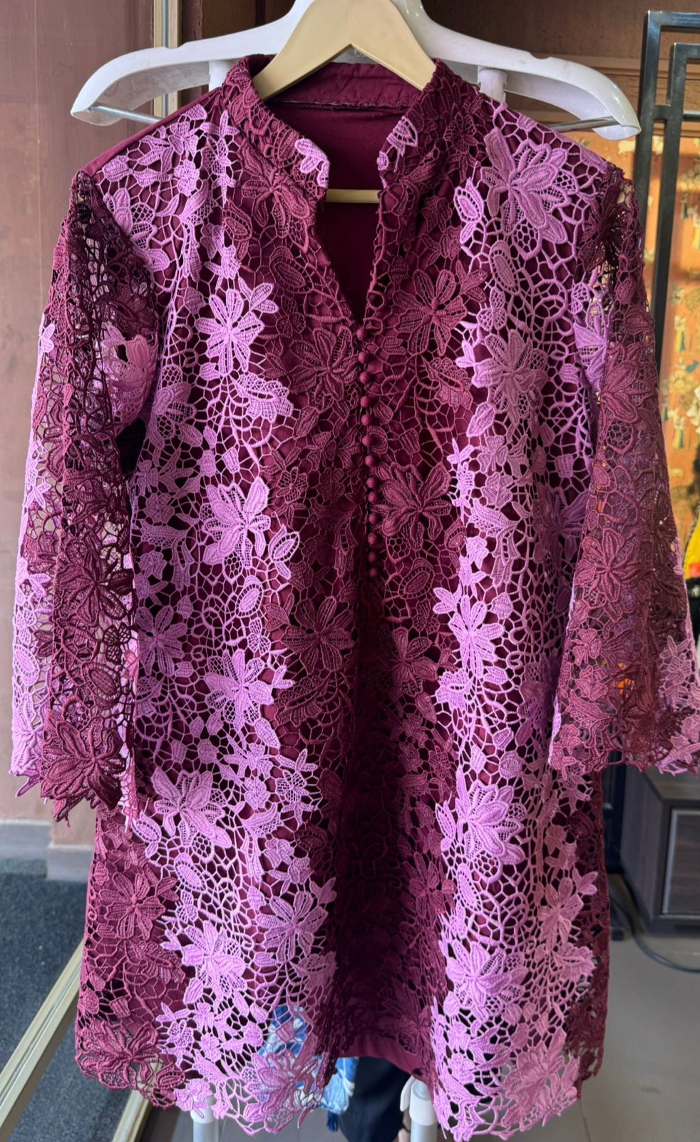 The outfit in the image features a beautiful, intricate lace fabric