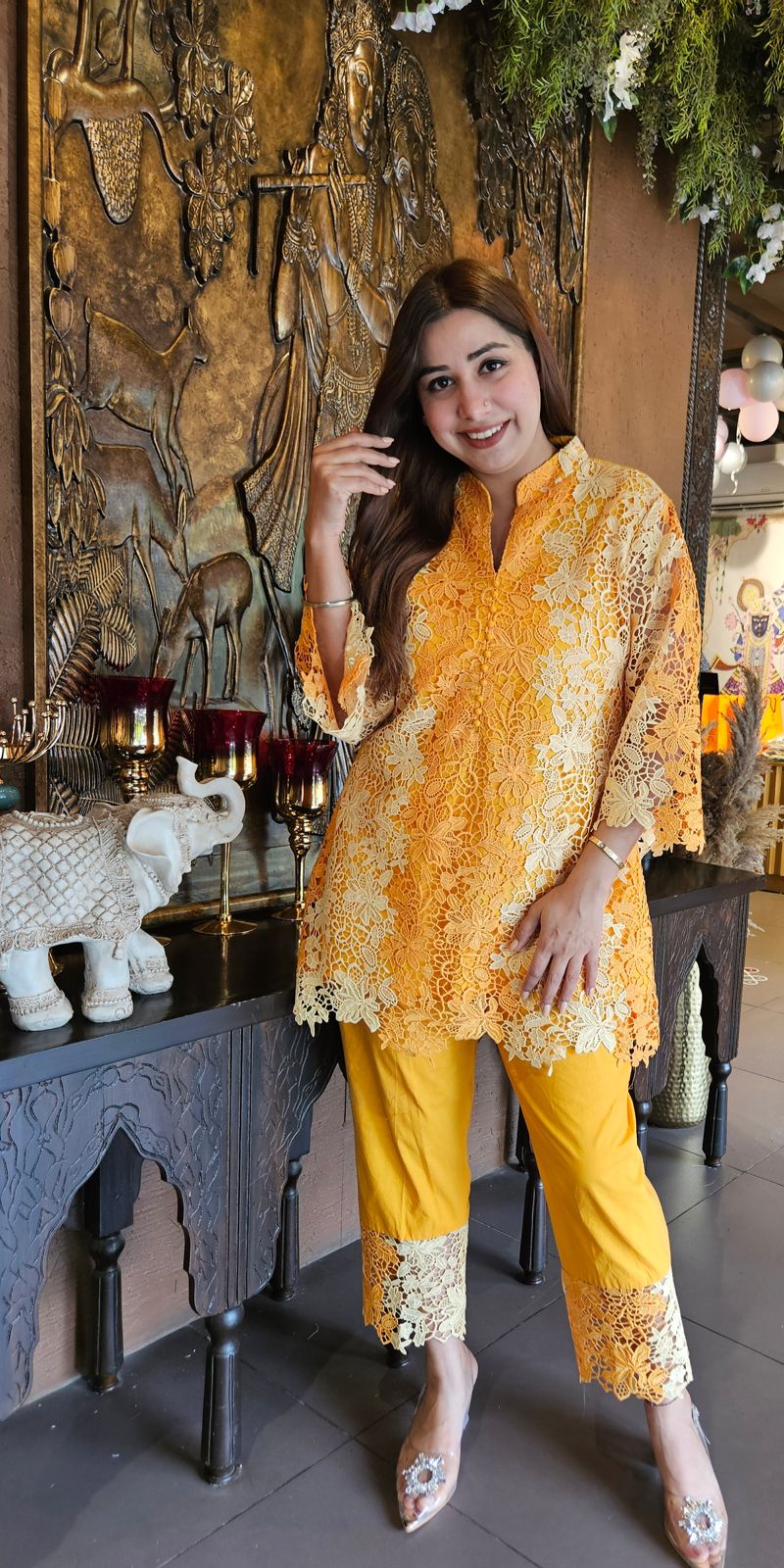 The outfit in the image features a beautiful, intricate lace fabric