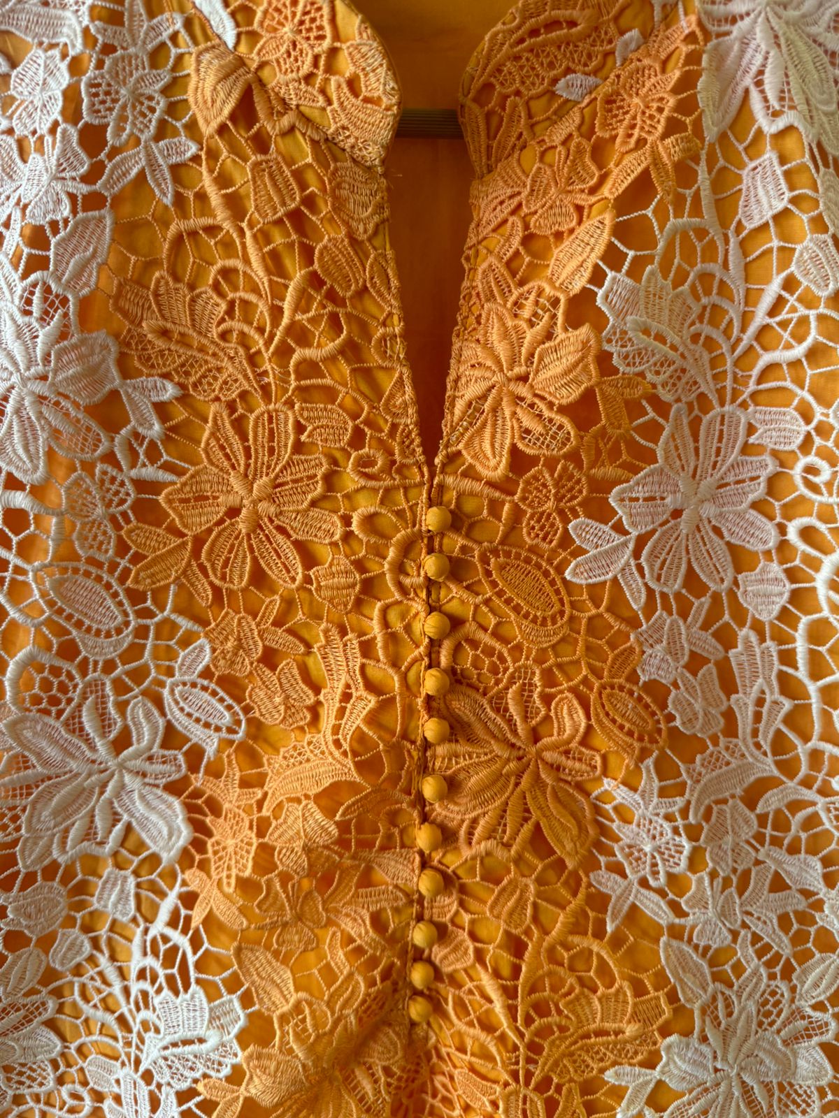 The outfit in the image features a beautiful, intricate lace fabric