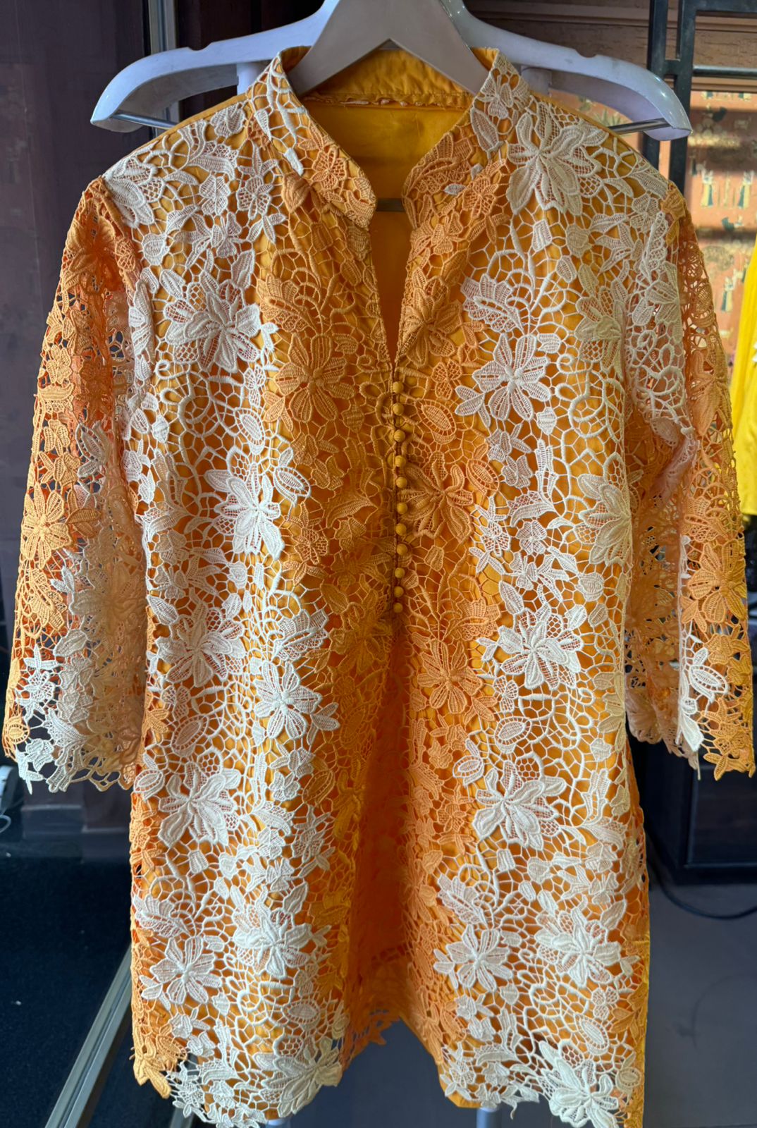 The outfit in the image features a beautiful, intricate lace fabric