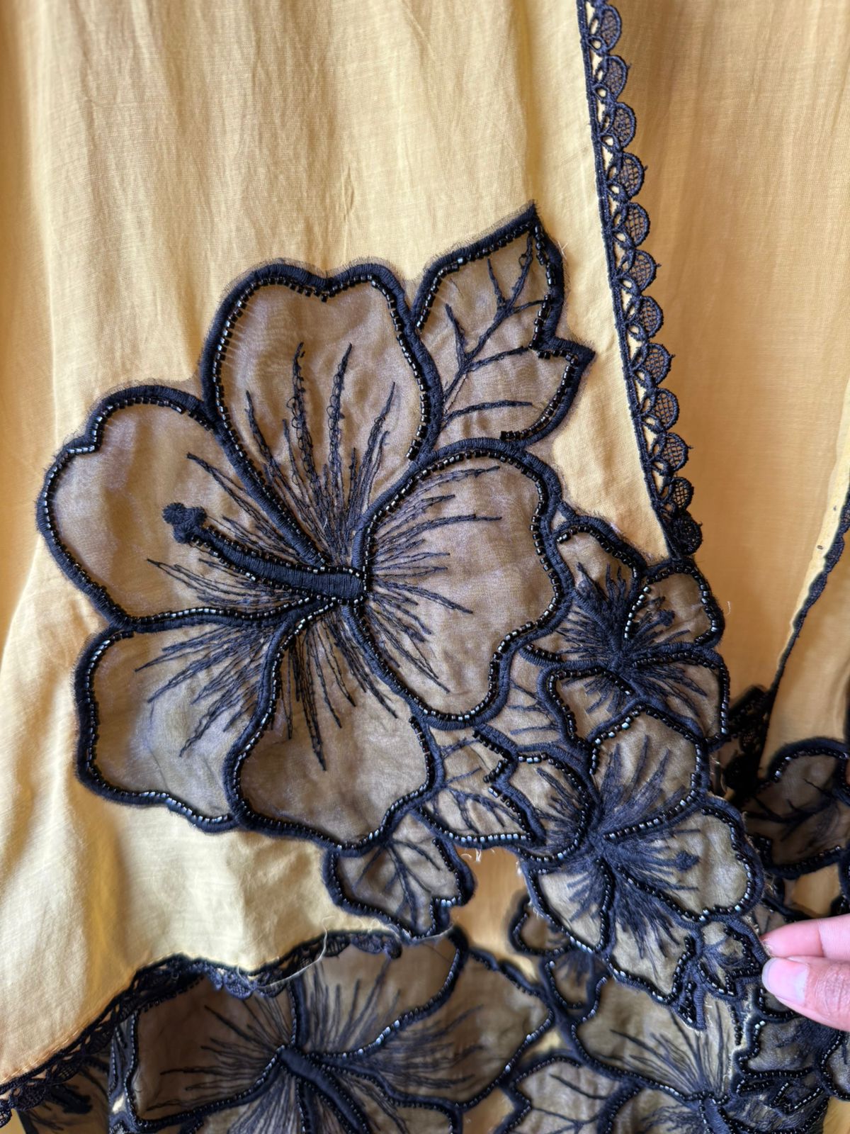 Graceful ensemble featuring large floral appliqué work with delicate thread