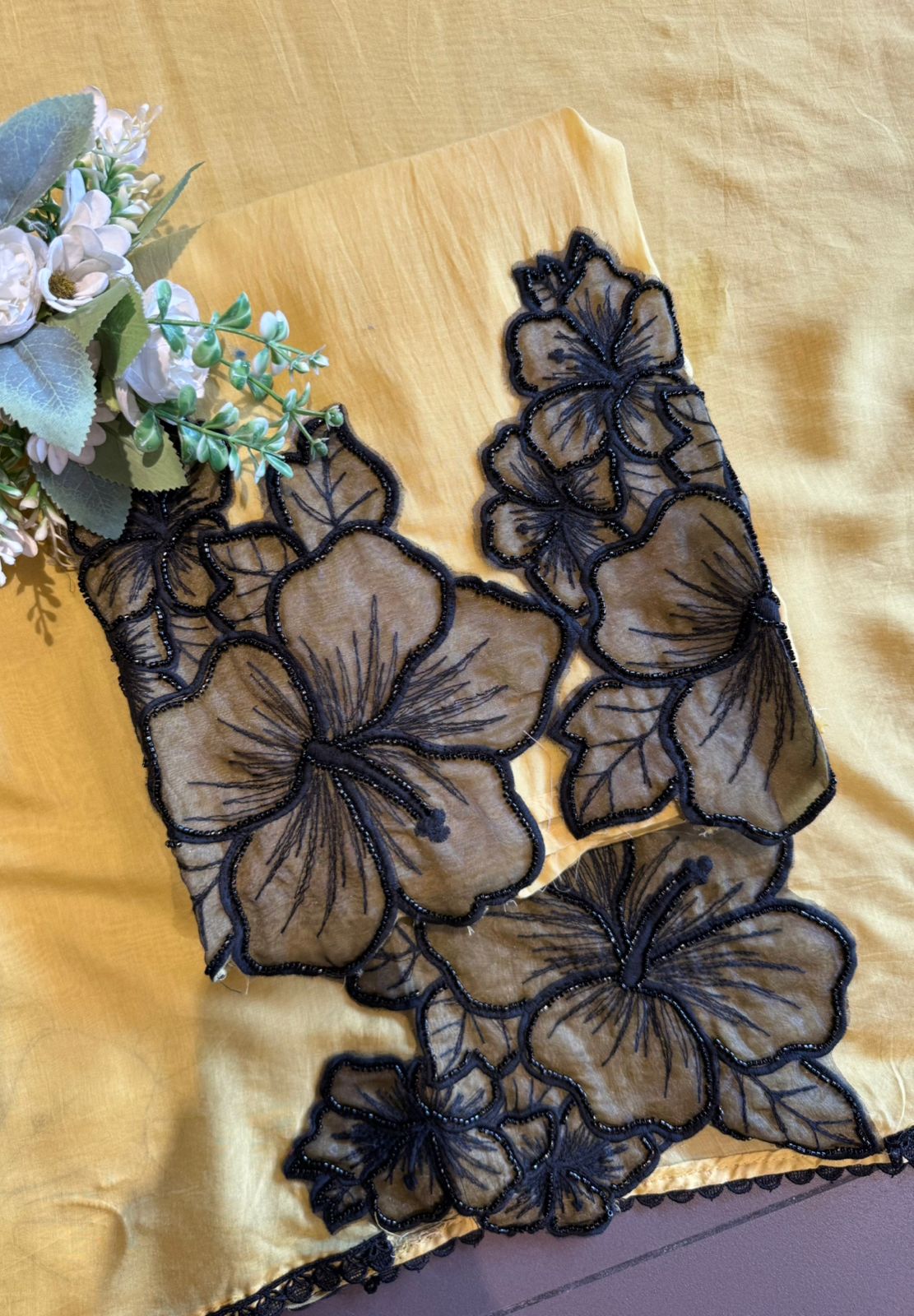 Graceful ensemble featuring large floral appliqué work with delicate thread