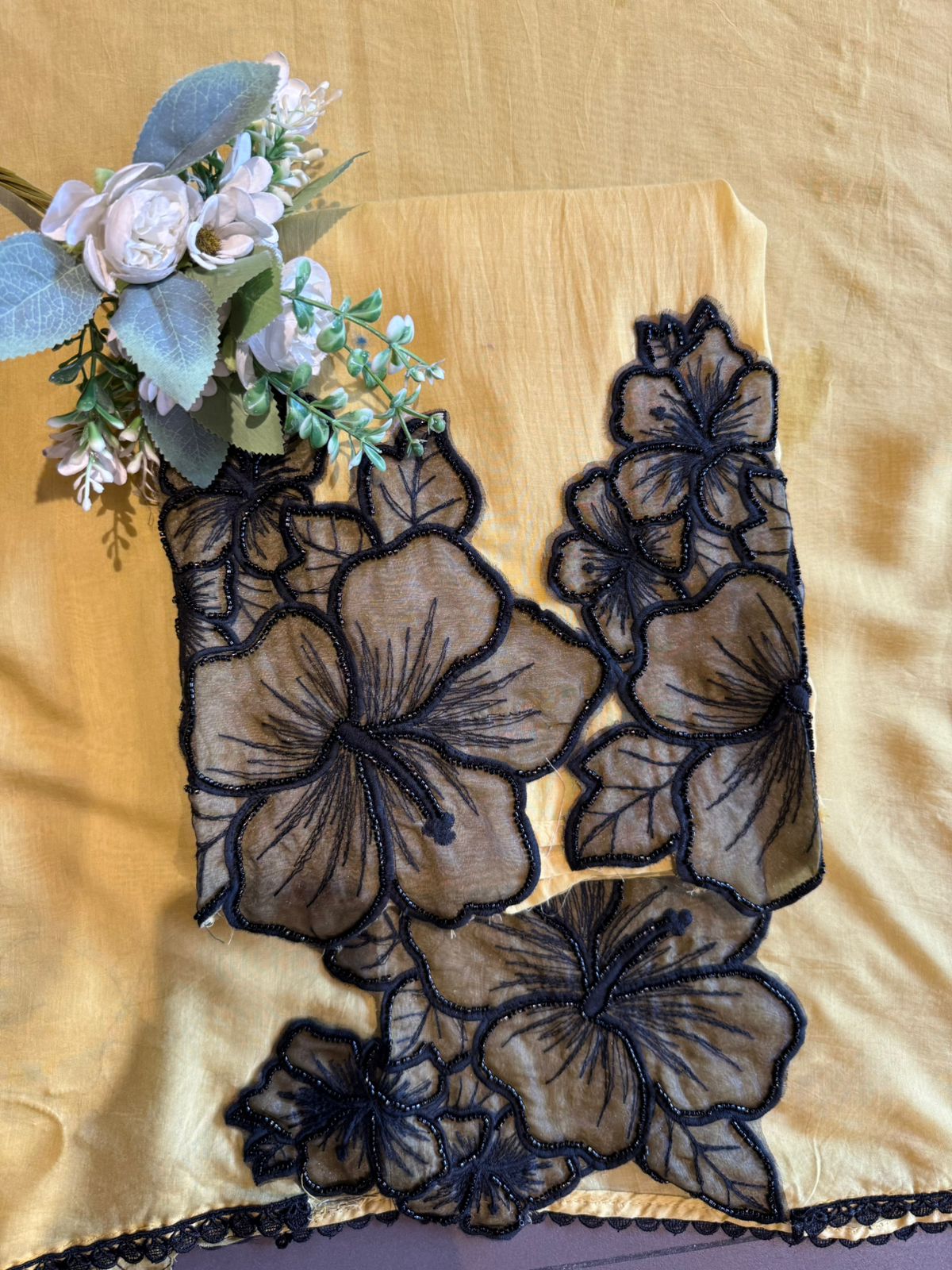 Graceful ensemble featuring large floral appliqué work with delicate thread