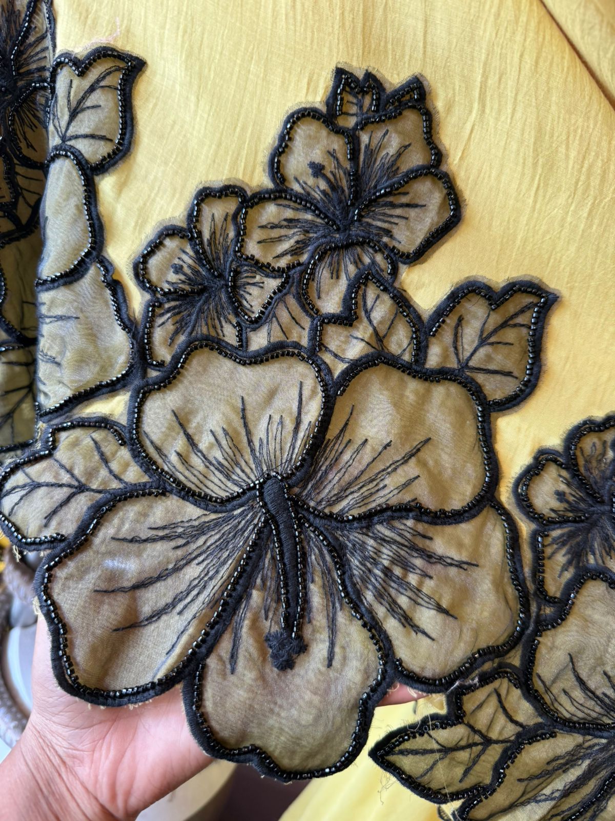 Graceful ensemble featuring large floral appliqué work with delicate thread