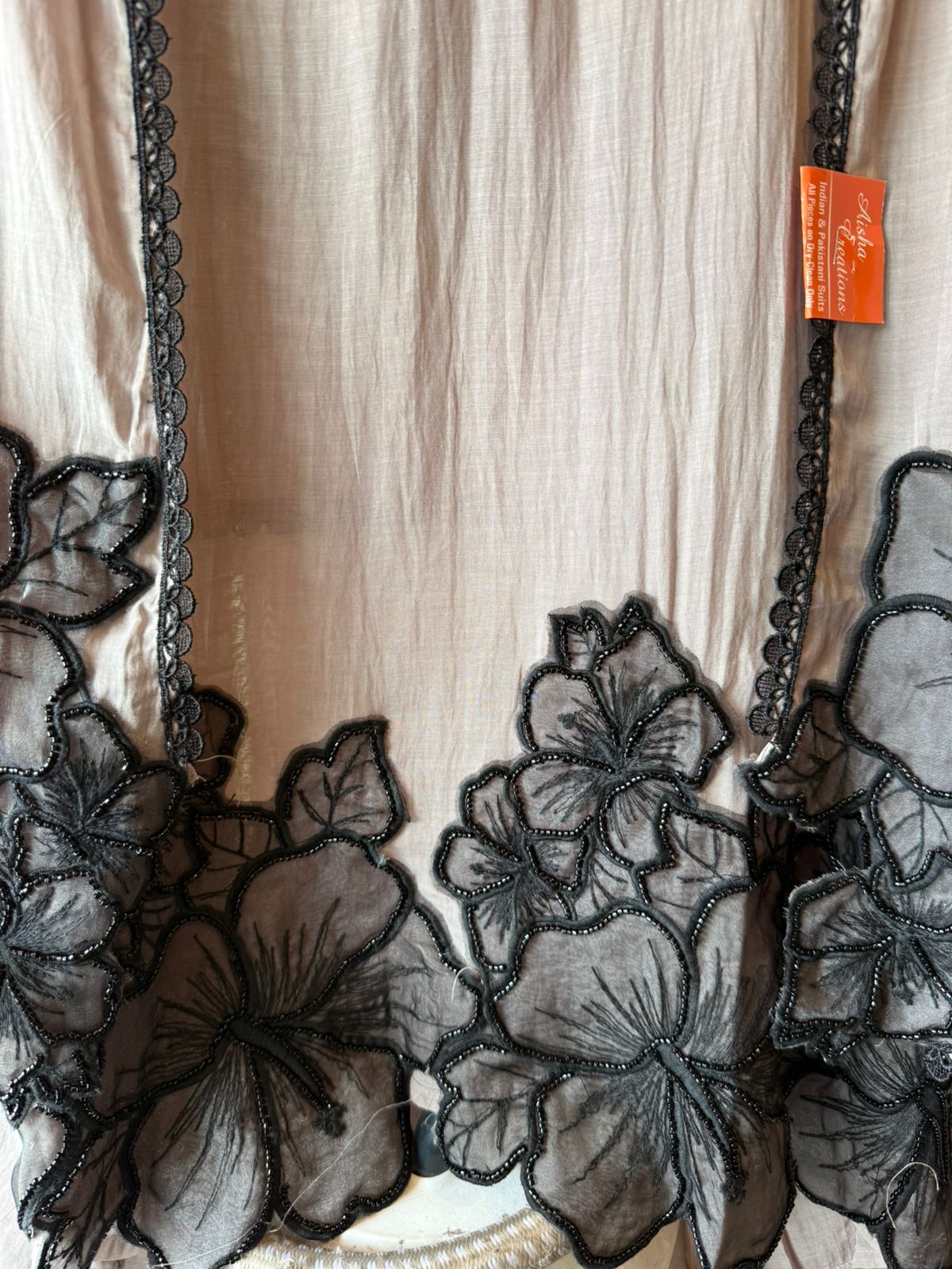 Graceful ensemble featuring large floral appliqué work with delicate thread