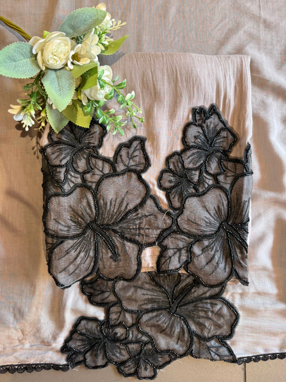 Graceful ensemble featuring large floral appliqué work with delicate thread